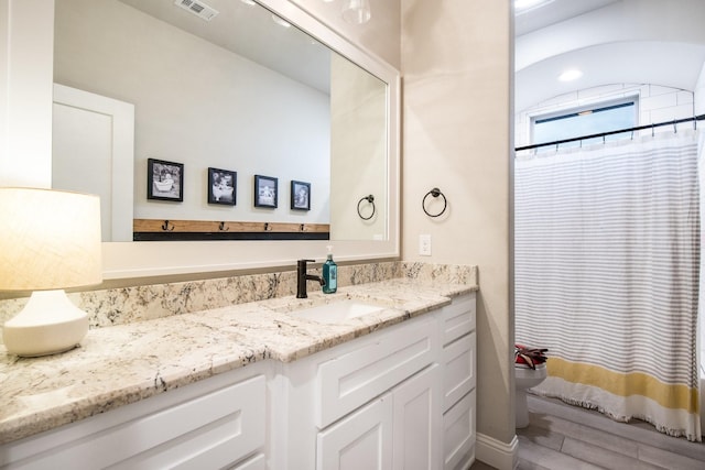 bathroom with vanity, a shower with curtain, wood finished floors, visible vents, and toilet