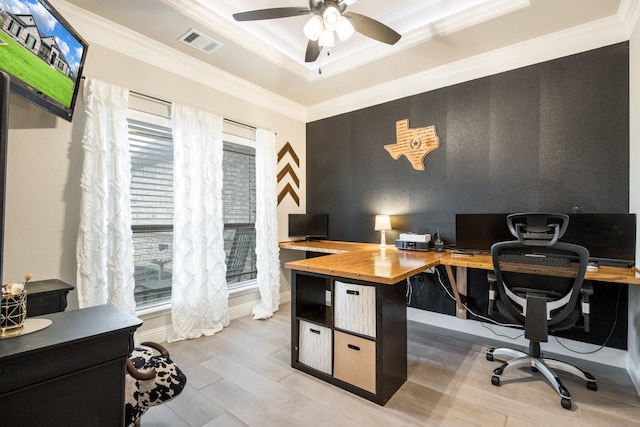 home office with a ceiling fan, visible vents, baseboards, a tray ceiling, and crown molding