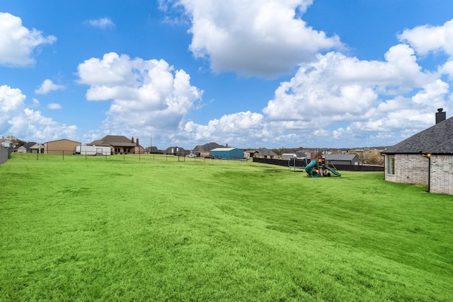 view of yard featuring a fenced backyard and playground community