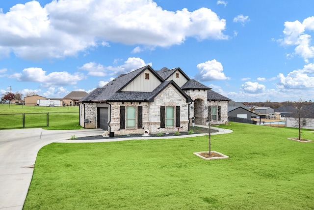 view of front of home featuring a front lawn, fence, board and batten siding, and driveway