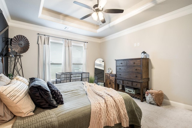 bedroom featuring visible vents, crown molding, baseboards, a tray ceiling, and carpet flooring