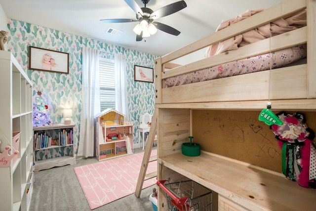 carpeted bedroom with visible vents, a ceiling fan, and wallpapered walls