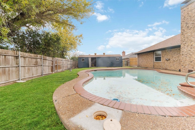 view of pool with a lawn