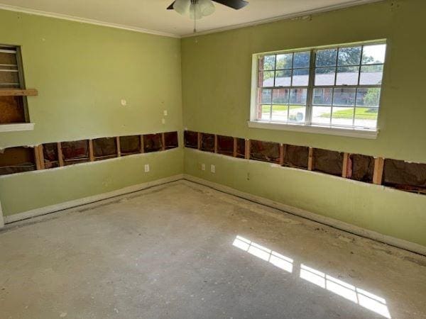 empty room featuring ceiling fan and ornamental molding