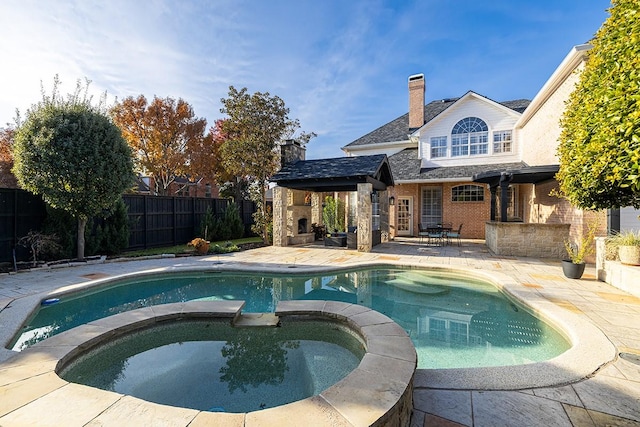 view of pool featuring a multi sided fireplace, an in ground hot tub, and a patio