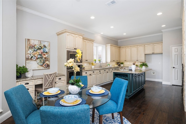 kitchen with dark hardwood / wood-style flooring, a center island, appliances with stainless steel finishes, and ornamental molding