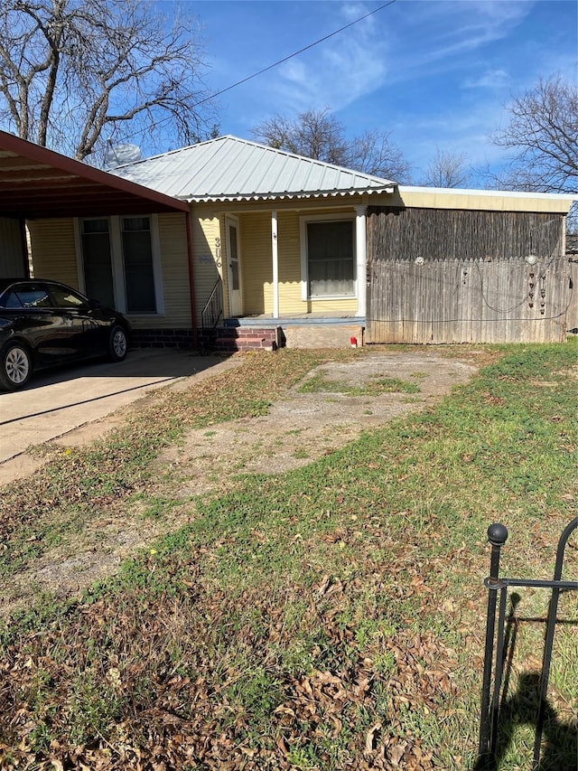 view of side of home featuring covered porch, a yard, and a carport