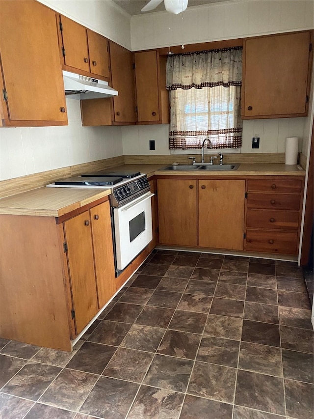 kitchen featuring ceiling fan, white gas stove, and sink