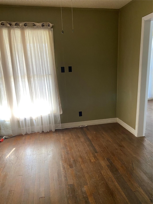 unfurnished room with a textured ceiling and dark hardwood / wood-style flooring