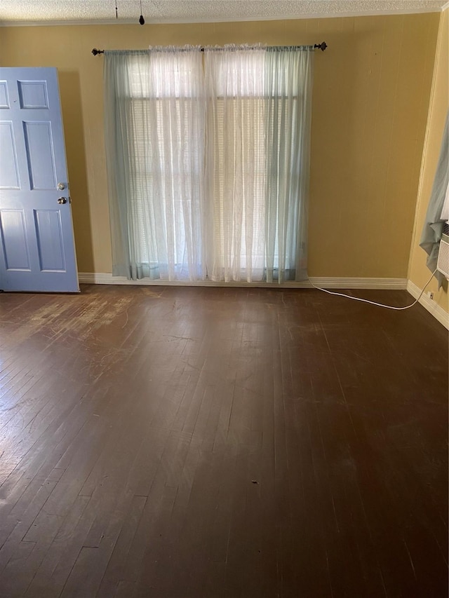 unfurnished room featuring a textured ceiling and dark wood-type flooring