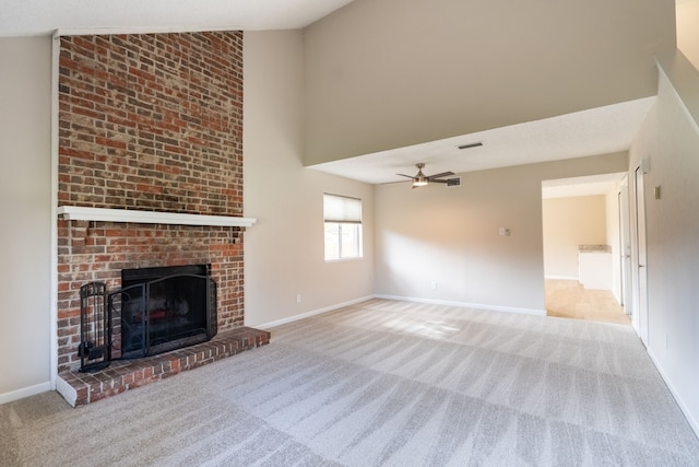 unfurnished living room with ceiling fan, high vaulted ceiling, light colored carpet, and a brick fireplace