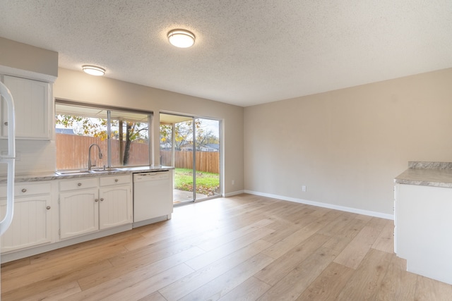 kitchen with white cabinetry, white dishwasher, a healthy amount of sunlight, and light wood-type flooring