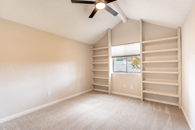 unfurnished bedroom featuring carpet flooring, ceiling fan, and lofted ceiling with beams