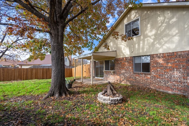 back of house with an outdoor fire pit, a patio area, and a lawn