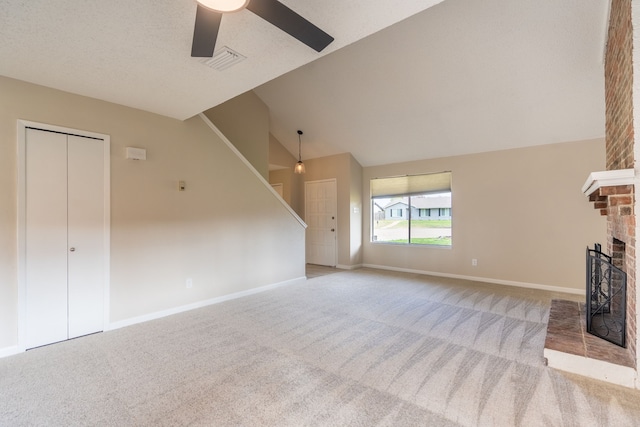 unfurnished living room with lofted ceiling, light carpet, ceiling fan, a textured ceiling, and a fireplace