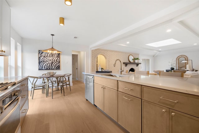 kitchen with sink, pendant lighting, light hardwood / wood-style floors, light brown cabinetry, and appliances with stainless steel finishes