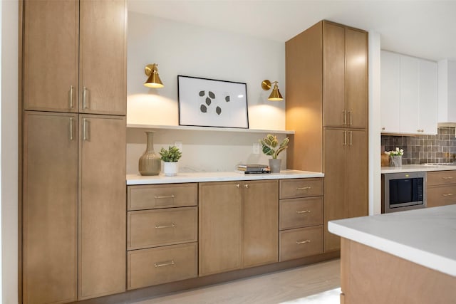 kitchen featuring stovetop, light hardwood / wood-style floors, wine cooler, and tasteful backsplash