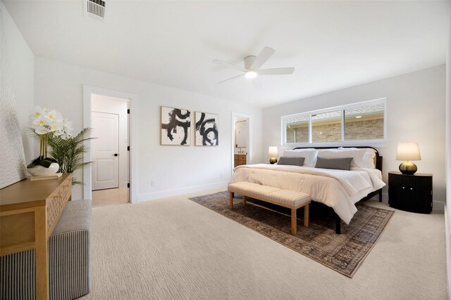 carpeted bedroom featuring ensuite bath and ceiling fan