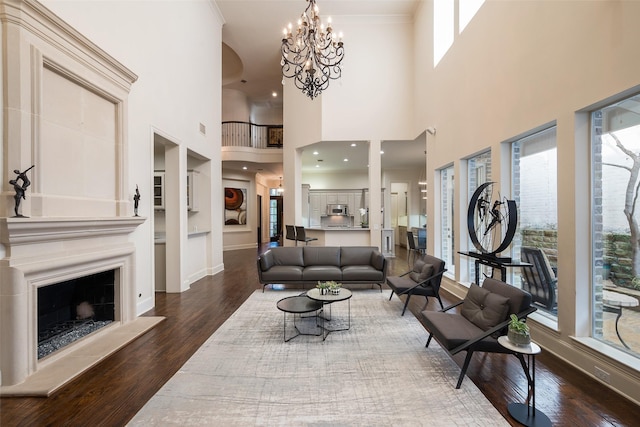 living room with a notable chandelier, dark hardwood / wood-style floors, a high ceiling, and a wealth of natural light