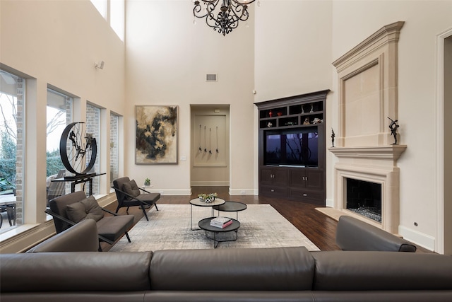 living room with dark hardwood / wood-style flooring, a chandelier, and a high ceiling