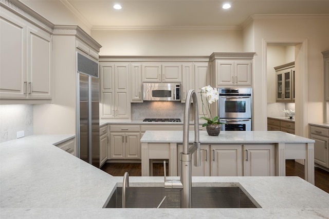 kitchen with a center island, backsplash, stainless steel appliances, and crown molding