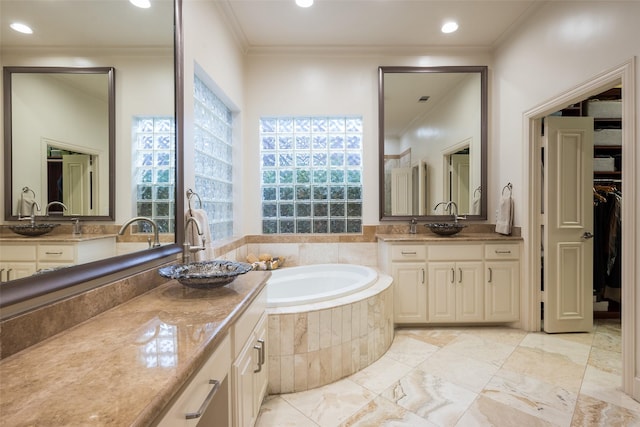 bathroom with tiled tub, crown molding, and vanity