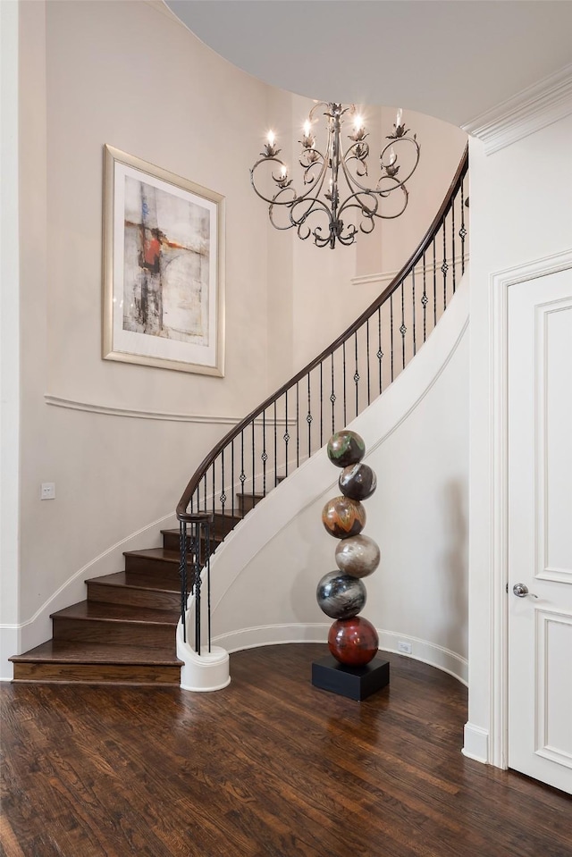 staircase featuring wood-type flooring and a notable chandelier