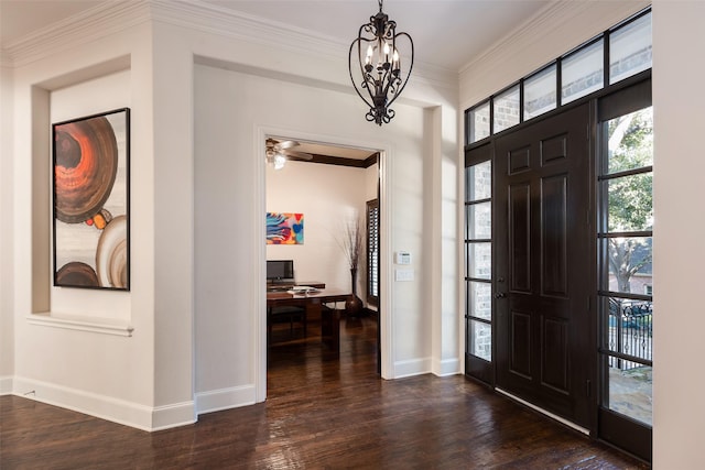 foyer with crown molding, dark wood-type flooring, and a notable chandelier