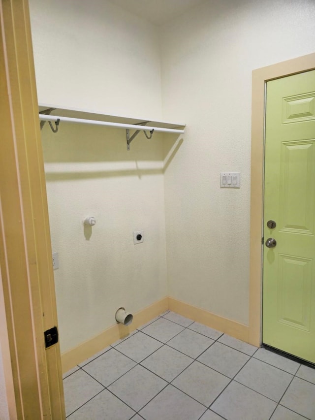 laundry area with electric dryer hookup and light tile patterned floors