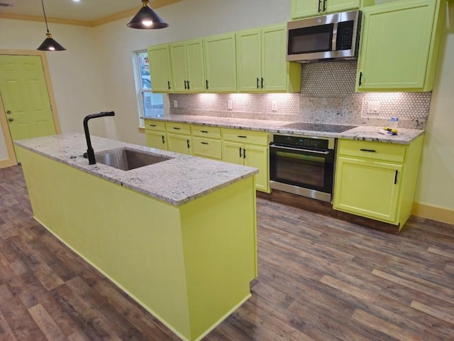 kitchen featuring sink, light stone counters, hanging light fixtures, appliances with stainless steel finishes, and a kitchen island with sink