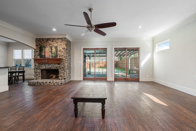 unfurnished living room with a fireplace, dark hardwood / wood-style flooring, ceiling fan, and crown molding