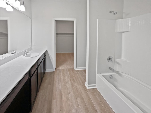 bathroom featuring hardwood / wood-style floors, vanity, and bathing tub / shower combination