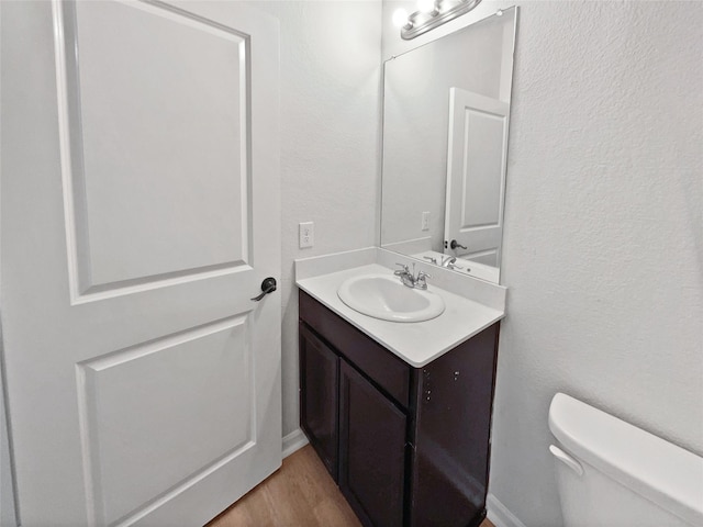 bathroom featuring hardwood / wood-style floors, vanity, and toilet