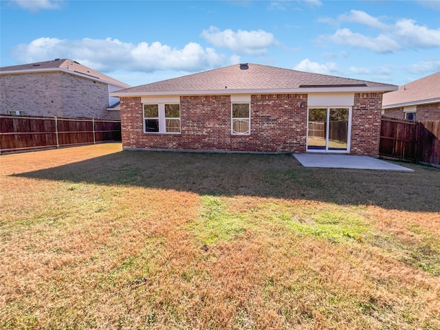 rear view of property with a yard and a patio area