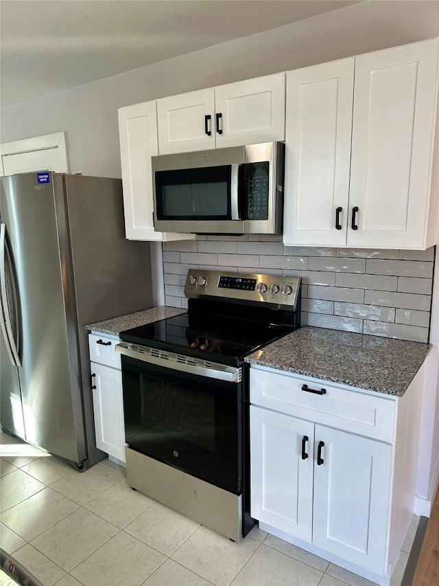 kitchen featuring stainless steel appliances, backsplash, white cabinetry, and light tile patterned floors