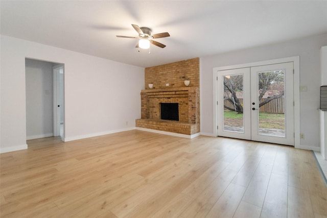 unfurnished living room with a fireplace, ceiling fan, french doors, and light hardwood / wood-style flooring