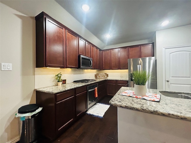 kitchen featuring sink, light stone countertops, stainless steel appliances, and dark wood-type flooring