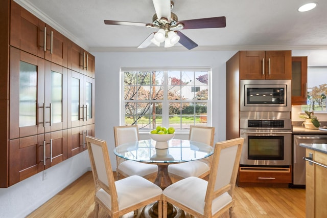 dining space featuring light hardwood / wood-style floors, ceiling fan, and ornamental molding