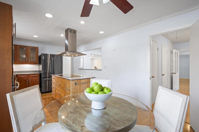 dining space featuring light hardwood / wood-style floors, ceiling fan, and crown molding