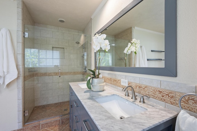 bathroom featuring backsplash, crown molding, vanity, and a shower with shower door