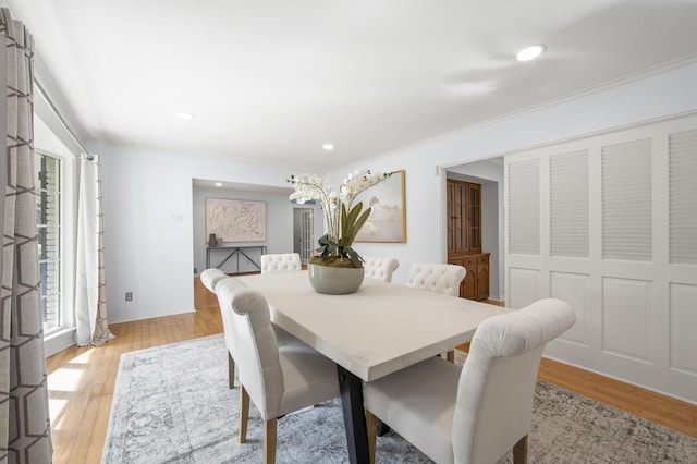 dining area featuring light hardwood / wood-style floors and crown molding