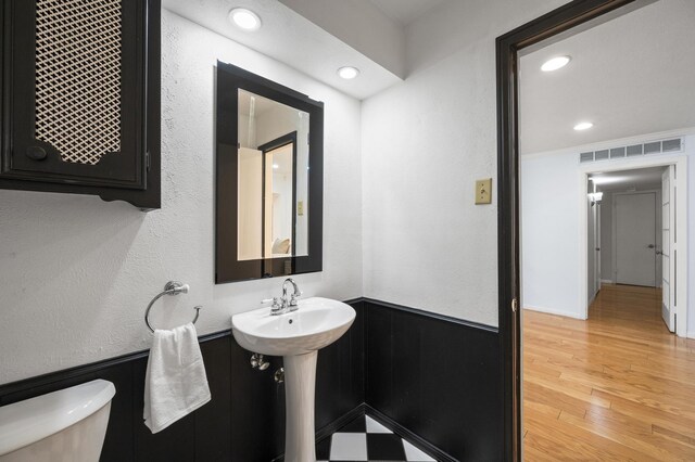 bathroom with hardwood / wood-style floors and toilet