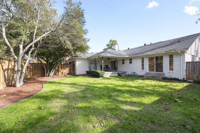 rear view of house with a yard, ceiling fan, and a patio area