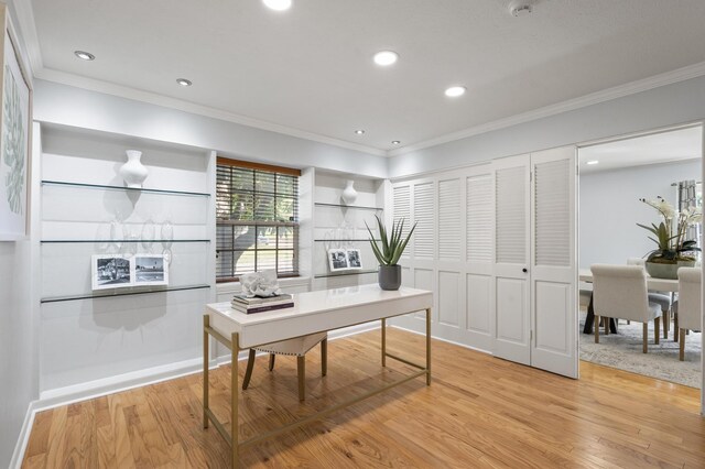 home office with light hardwood / wood-style floors and ornamental molding