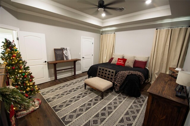 bedroom with a raised ceiling, ceiling fan, dark hardwood / wood-style flooring, and ornamental molding