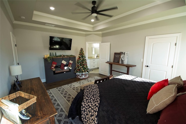 bedroom with a raised ceiling, ceiling fan, crown molding, and wood-type flooring