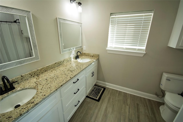 bathroom featuring wood-type flooring, vanity, toilet, and a shower with curtain