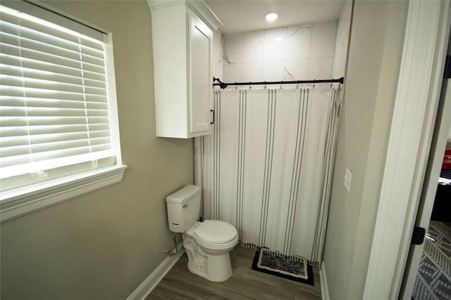 bathroom with hardwood / wood-style flooring, toilet, and walk in shower