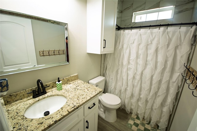 bathroom featuring a shower with curtain, hardwood / wood-style floors, vanity, and toilet