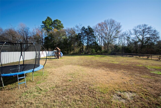 view of yard with a playground and a trampoline